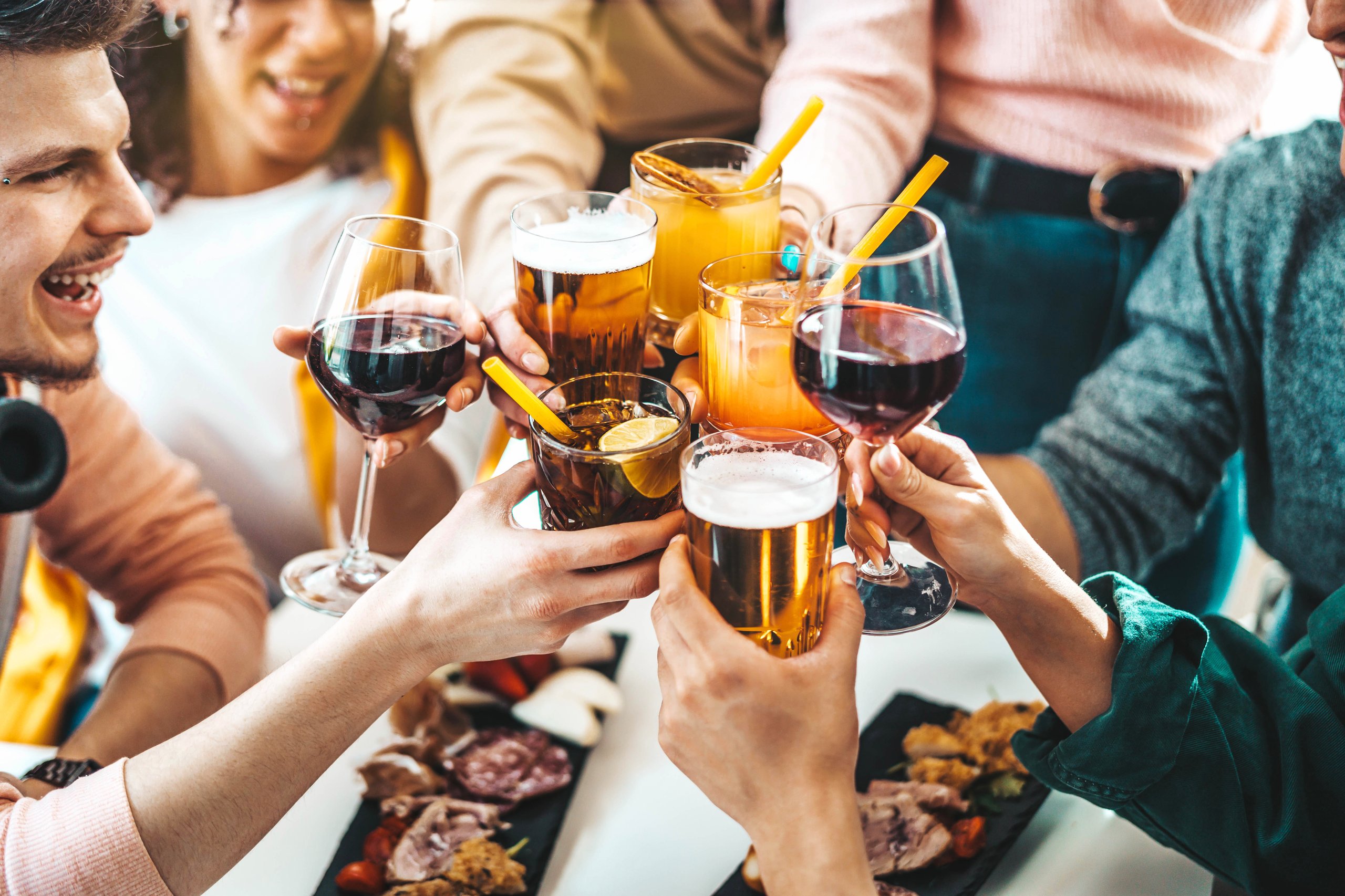 Multiracial friends celebrating party drinking cocktails at bar restaurant