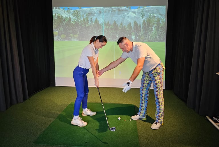Golf instruction session with coach and student at indoor simulator