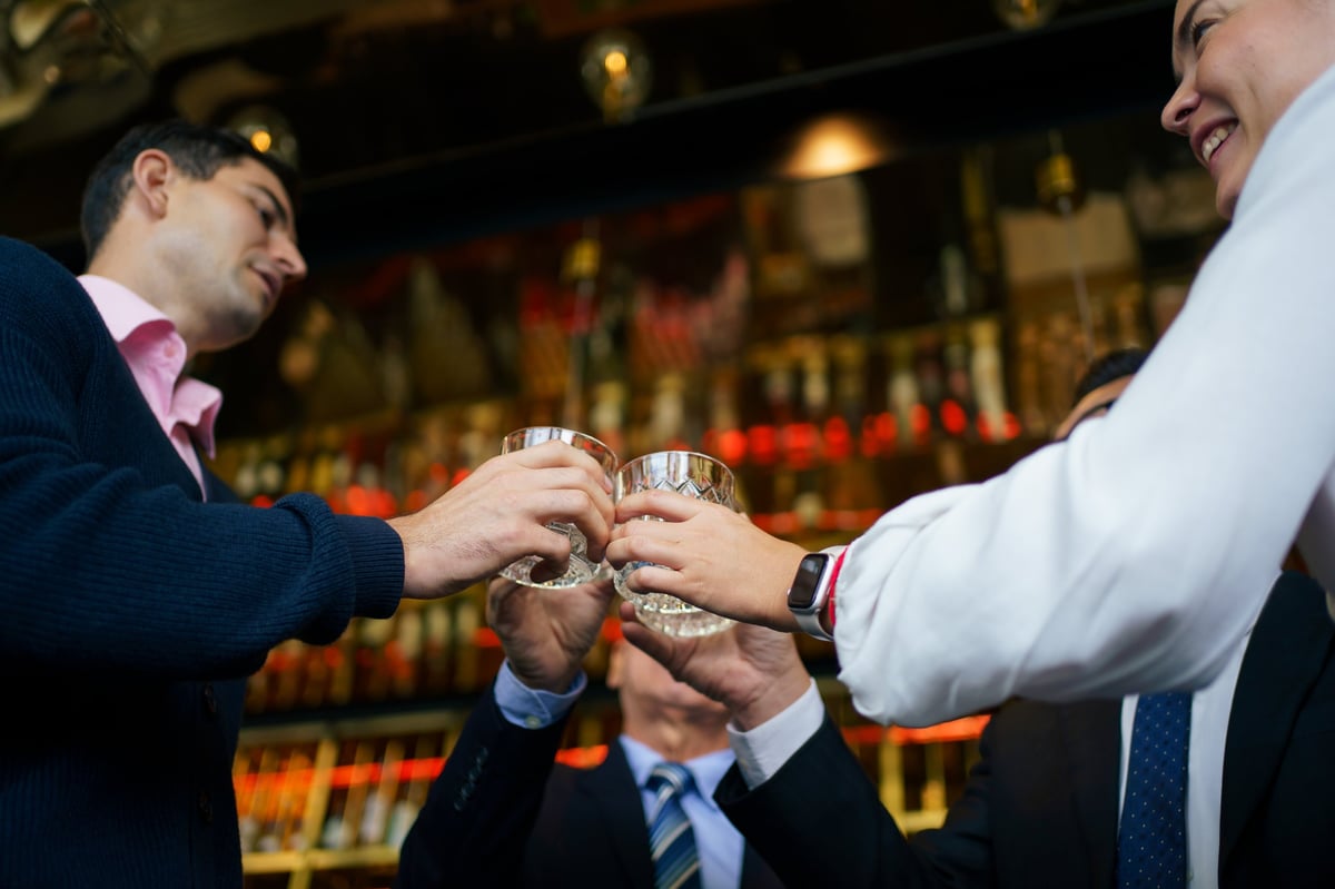 Business professionals networking at rooftop bar with drinks