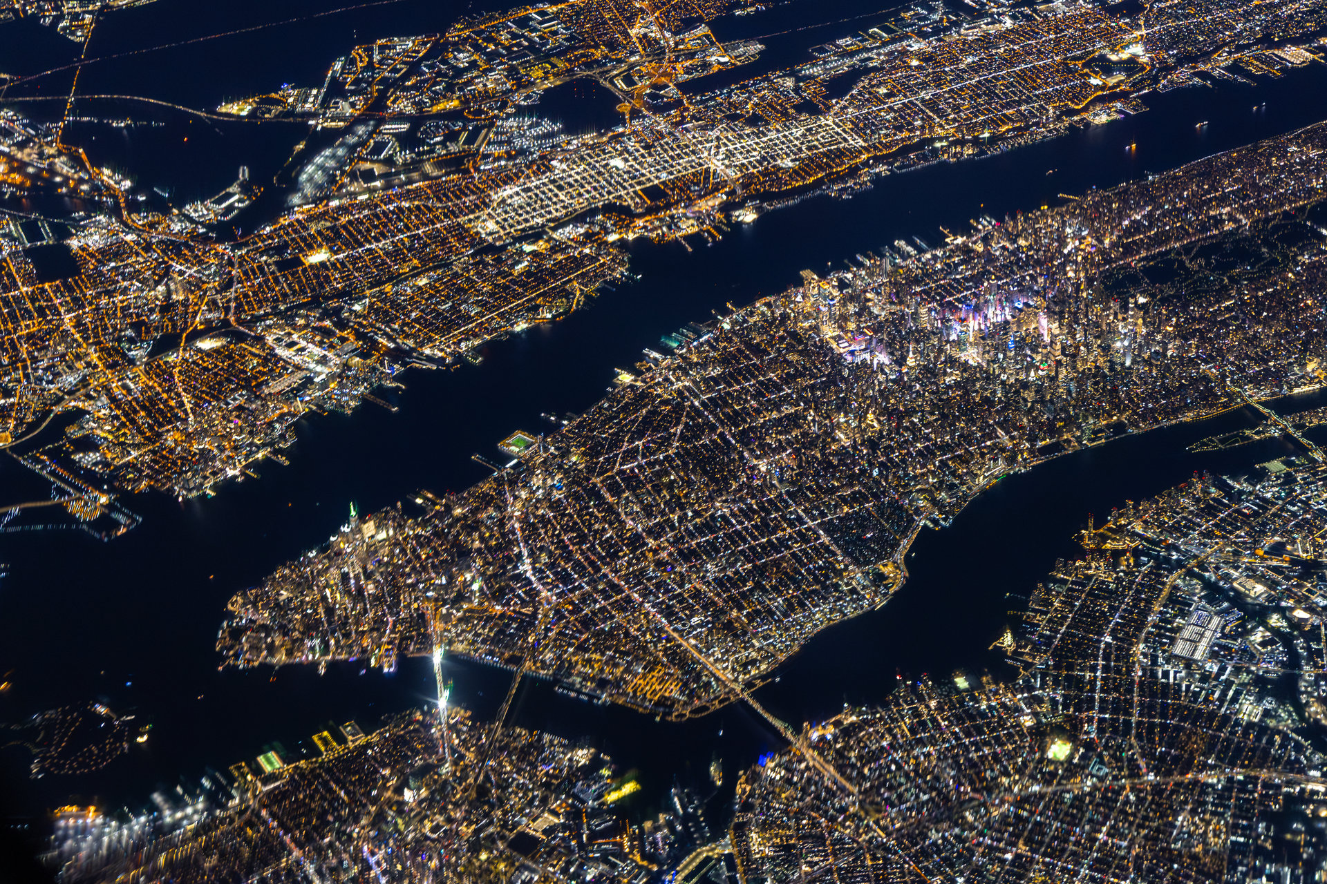 Aerial night view of Manhattan showing illuminated street grid