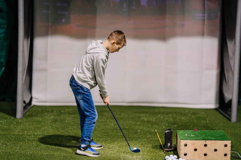 Young boy practicing golf indoors